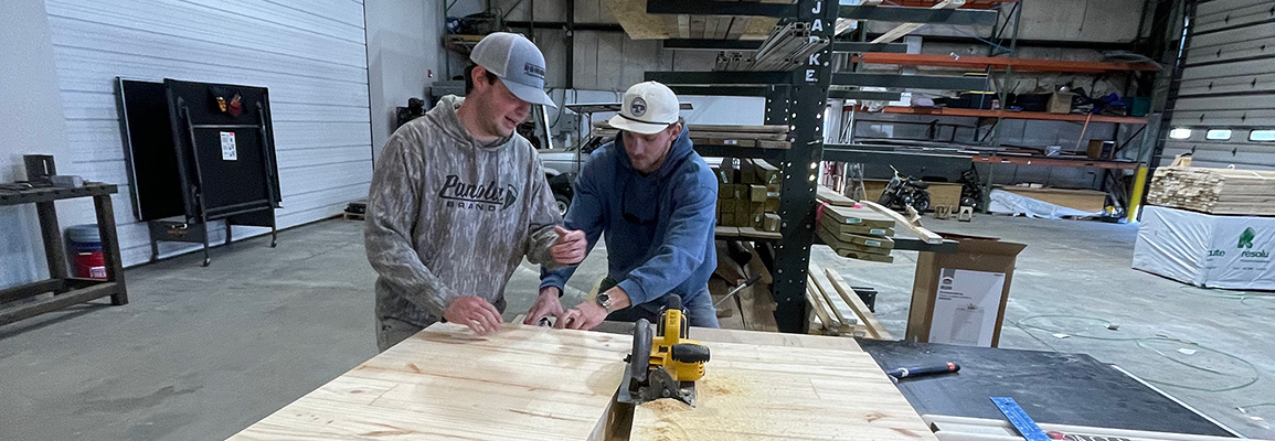 Students measuring in wood shop
