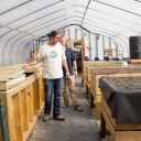 Inside the greenhouse, thermal battery (left) and raised aquaponics grow beds (right)